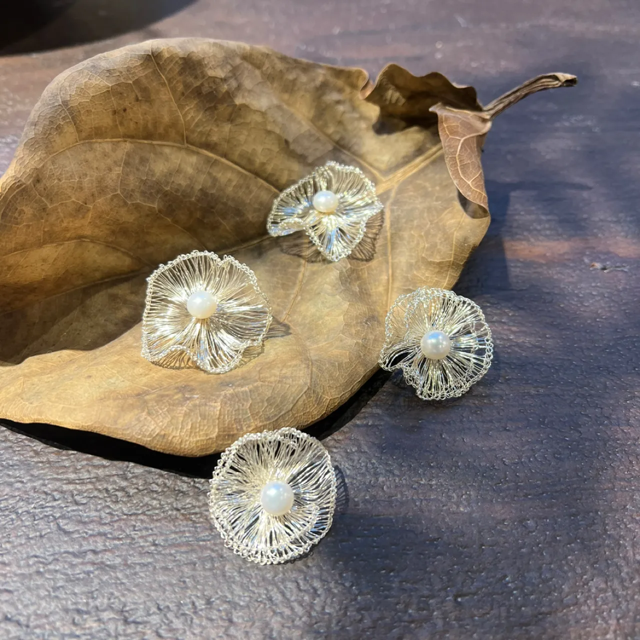 Handwoven silver-tone flower earrings with pearl-look centers