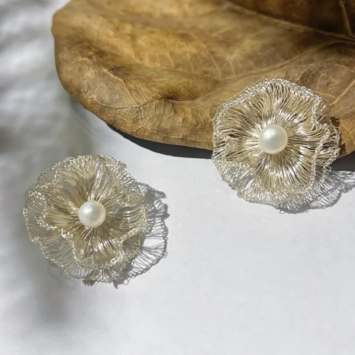 Pair of handwoven silver-tone wire flower earrings with pearl-look centers