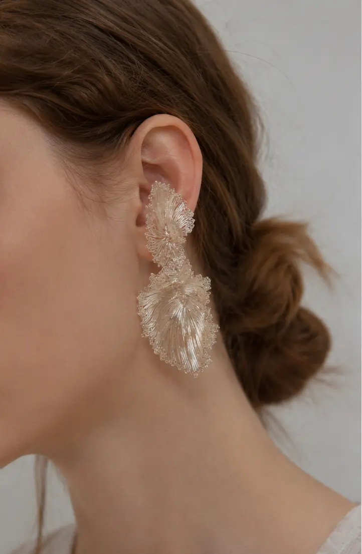 Woman wearing OREYNE fan palm leaf earrings