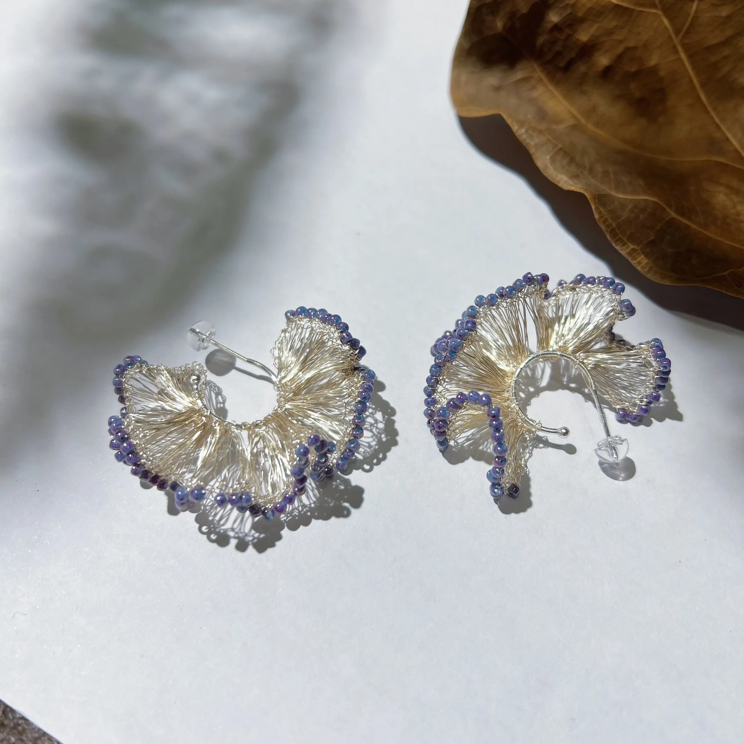 Pair of silver-tone wire fan earrings with purple bead trim