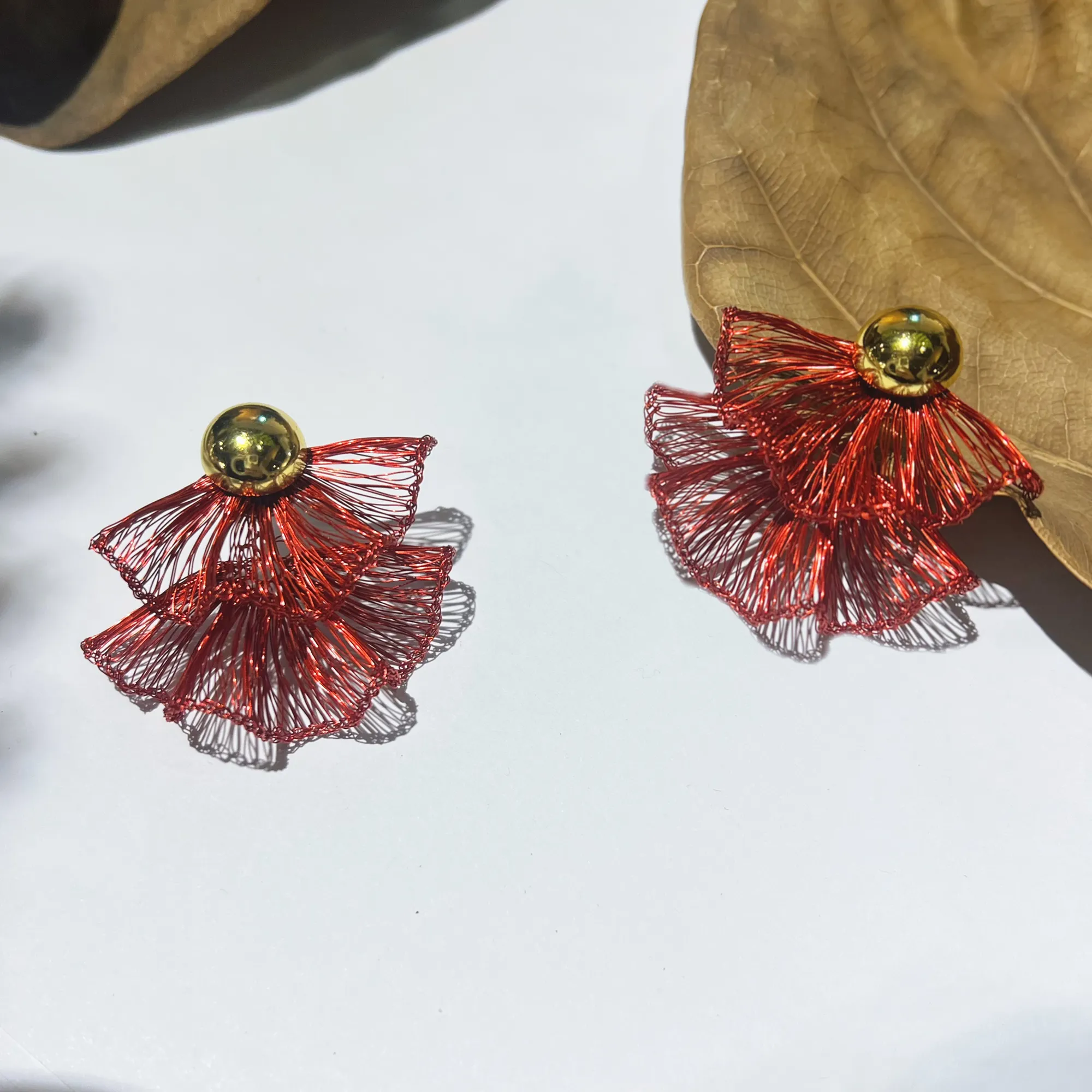 Red layered wire statement earrings with bold sculptural silhouette