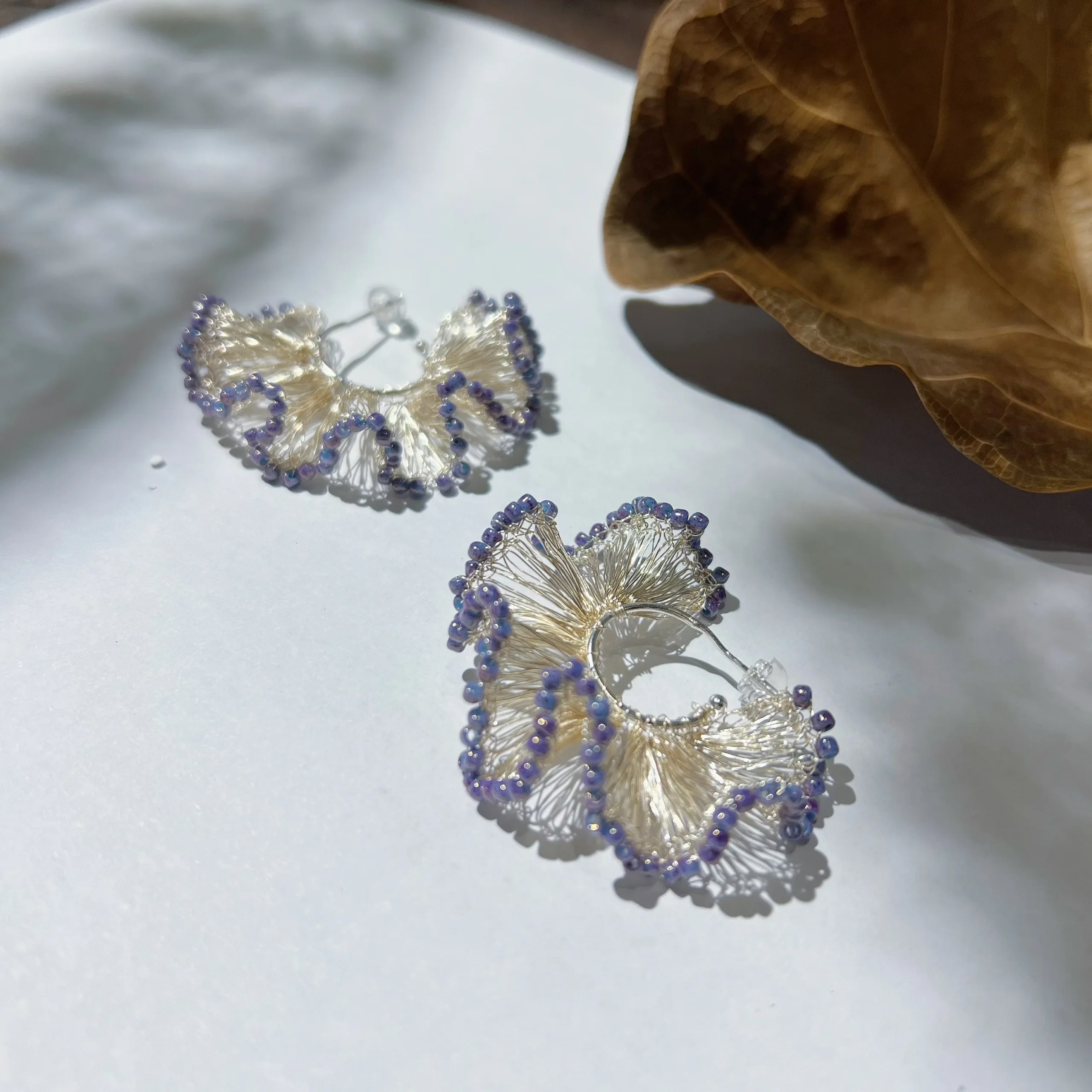 Sculptural silver-tone wire ginkgo earrings with purple bead edging