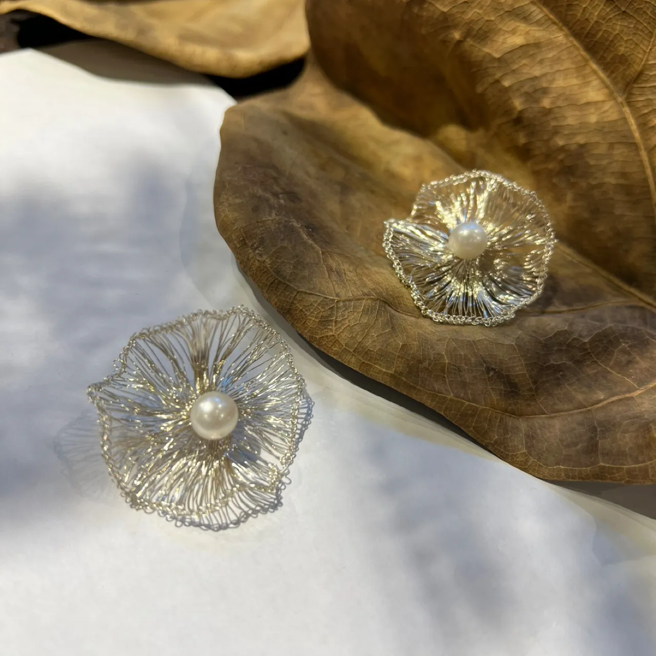 Pair of silver-tone flower statement earrings with pearl-look centers