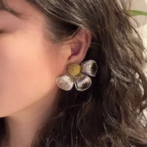 Woman wearing a handmade silver-tone wire flower statement earring