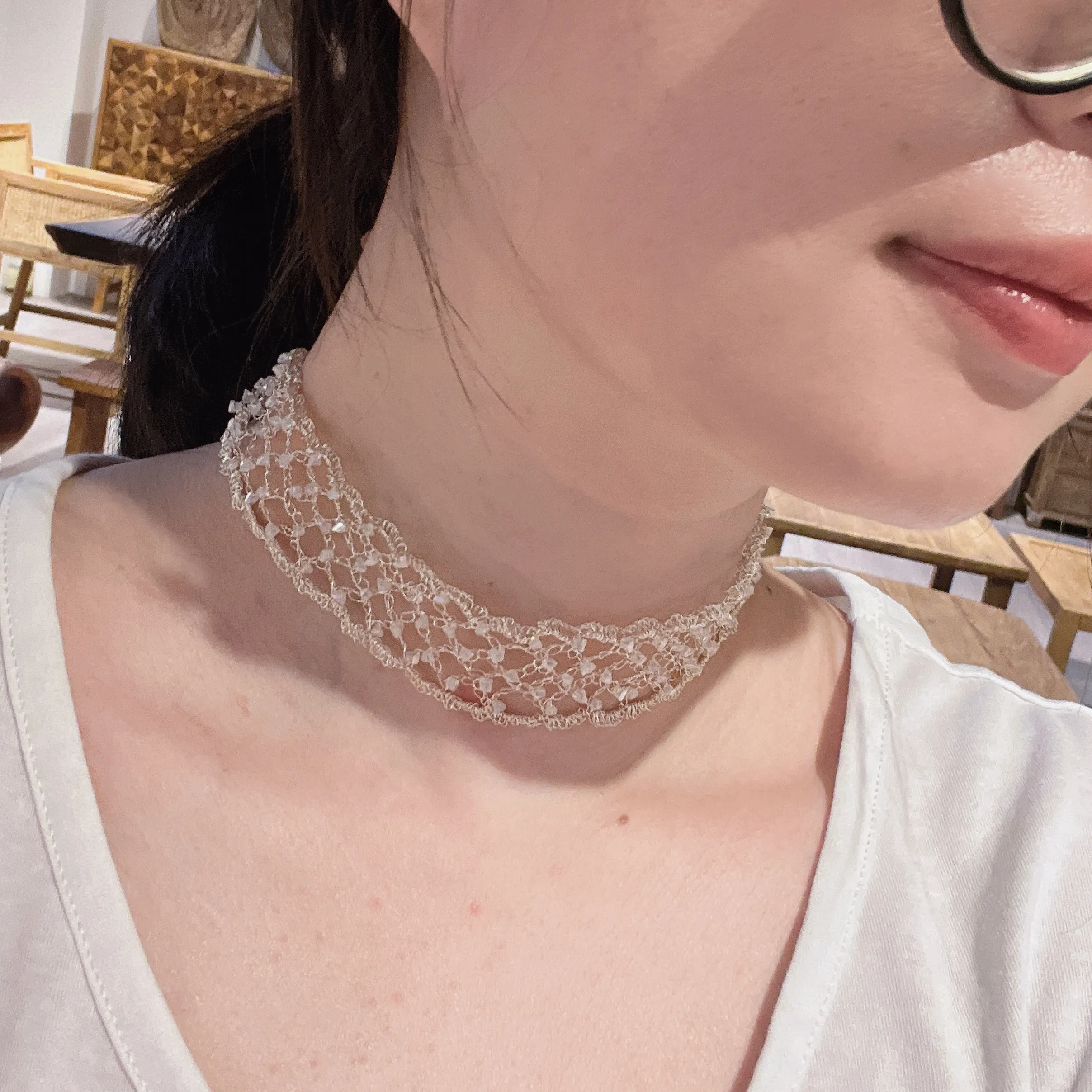 Handwoven metallic choker worn at the neck