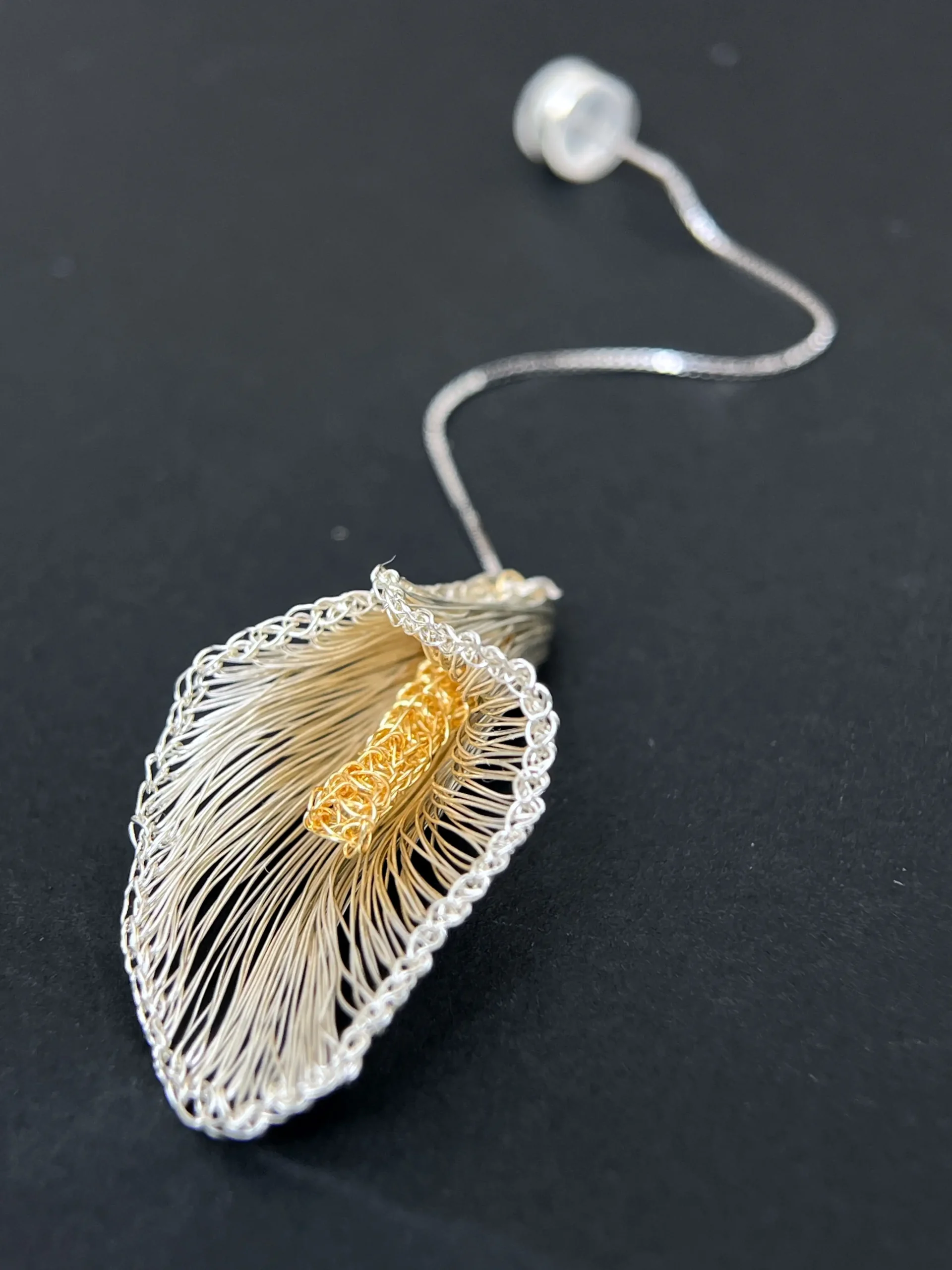 Close-up of handwoven openwork calla lily earrings with textured gold-tone centers