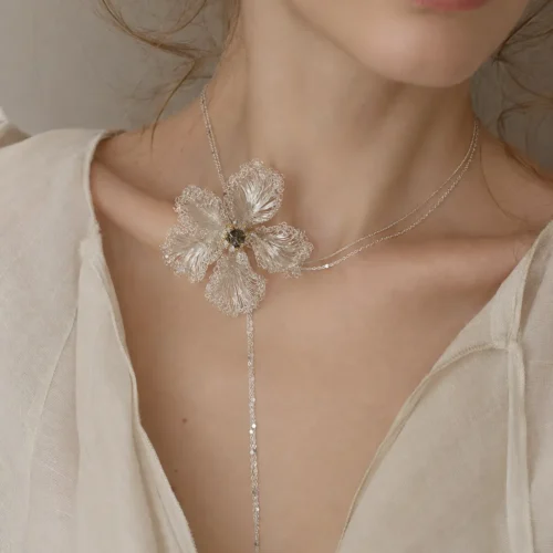 Model wearing the OREYNE White Musk Mallow sculptural flower necklace