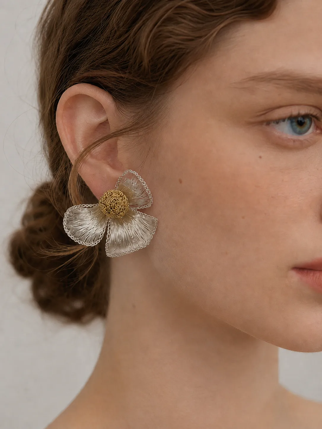 Woman wearing OREYNE dogwood flower earrings