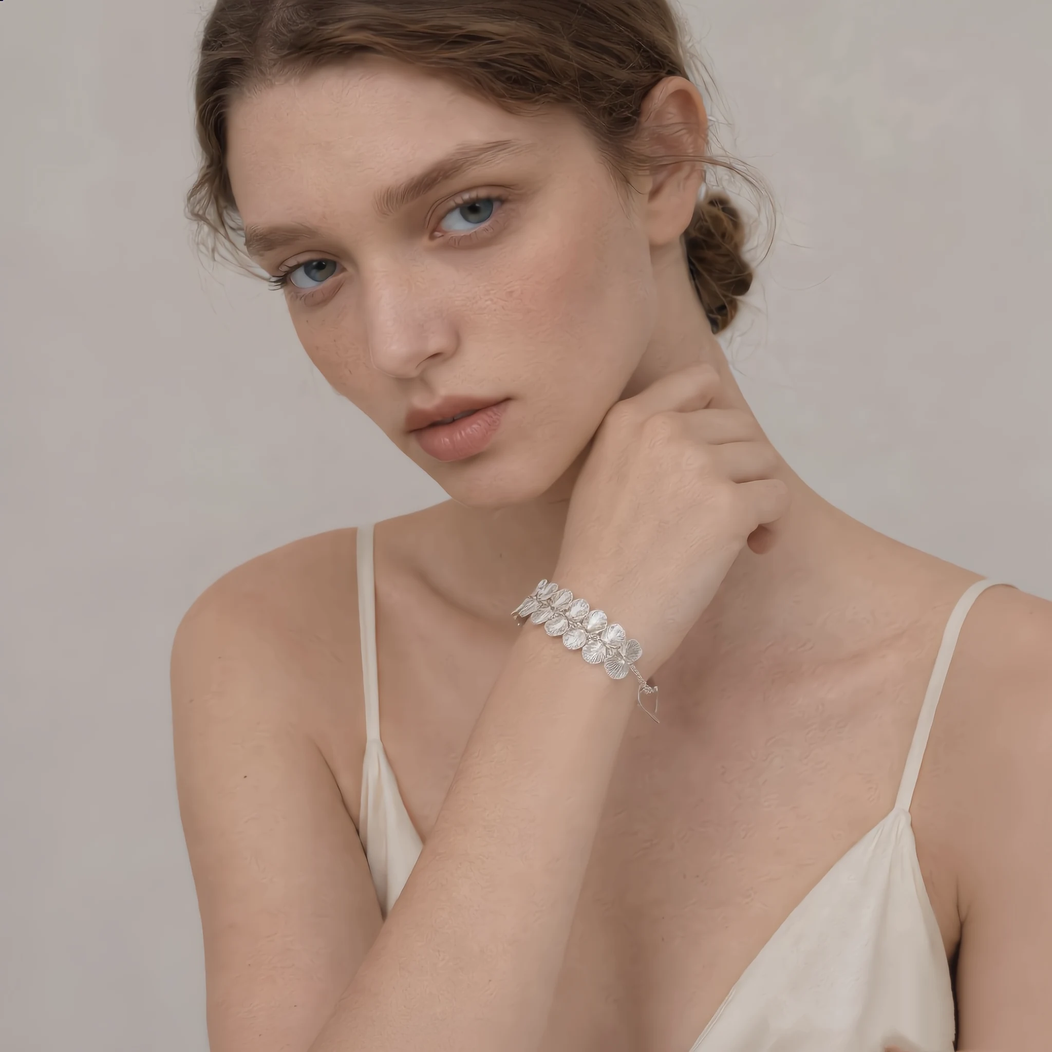 Silver-tone handwoven wire floral bracelet worn on the wrist with layered openwork flower details