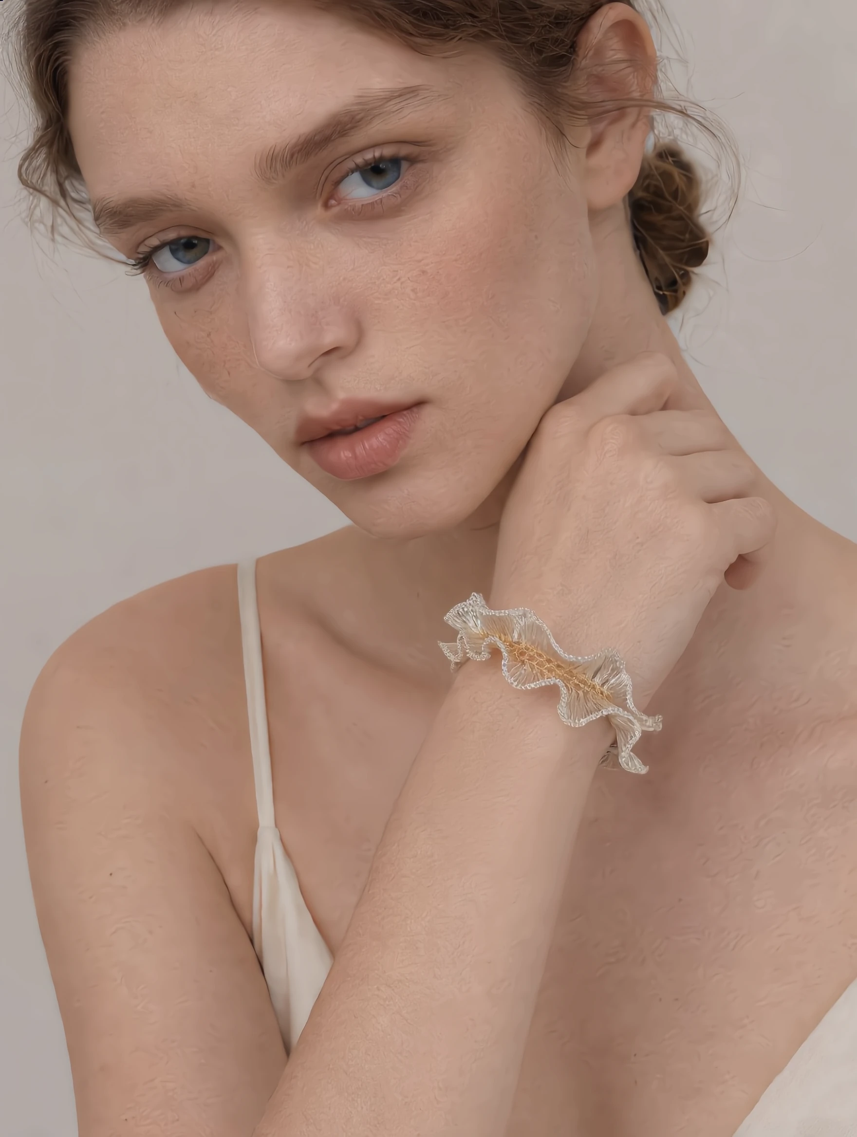 Silver-tone and gold-tone handwoven wire bracelet worn on the wrist