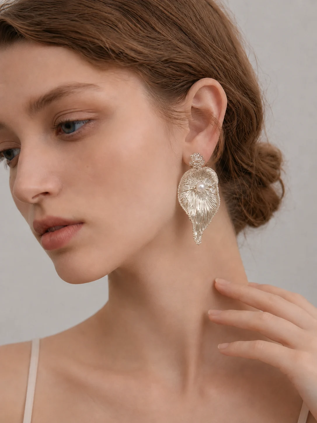 Lunelle Fold silver-tone sculptural handwoven metal earring worn in profile