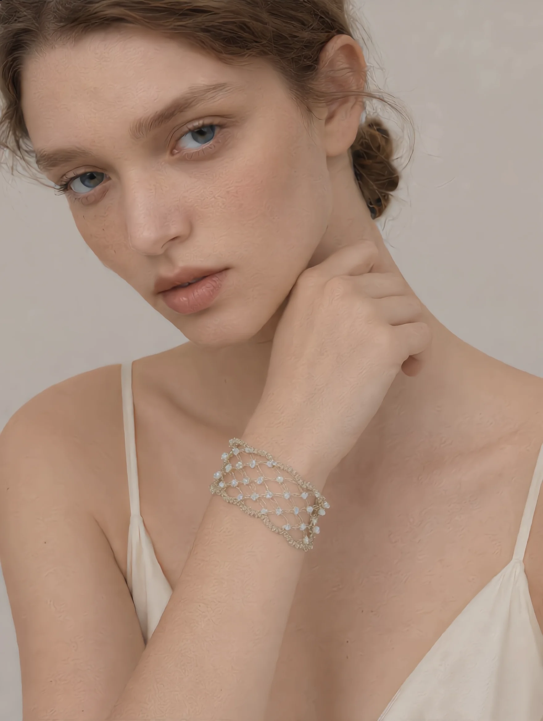 Front worn view of a silver-tone handwoven wire lace necklace with translucent decorative accents
