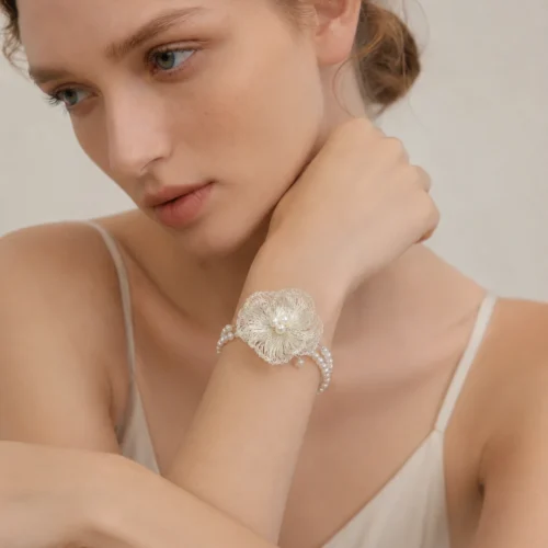 Close-up of model wearing OREYNE handcrafted floral wire bracelet with pearl accents