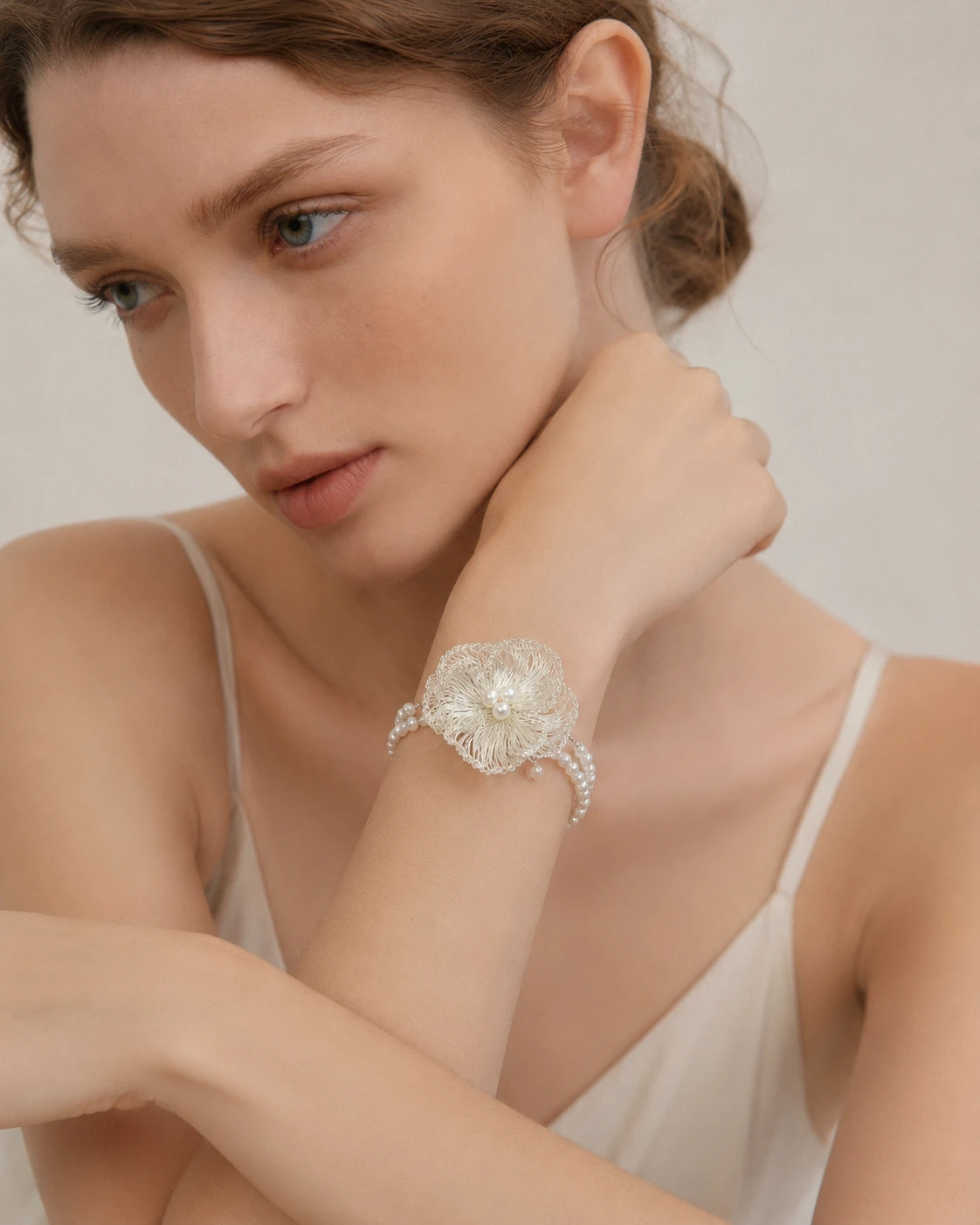 Woman wearing a handmade openwork flower statement earring with pearl-look accents