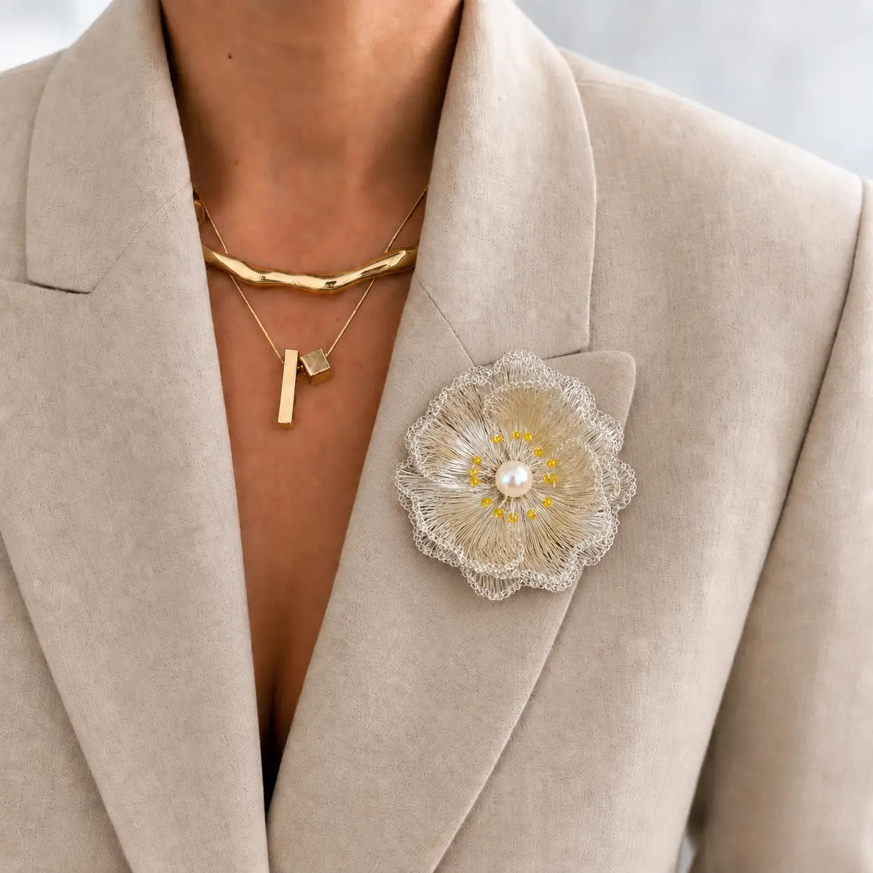 Liora silver-tone handwoven metal flower brooch styled in hand