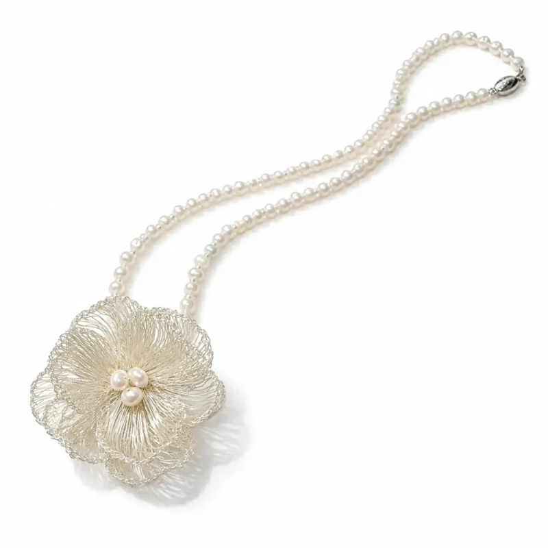 OREYNE handcrafted silver wire flower necklace with pearl strands and pearl center on a white background