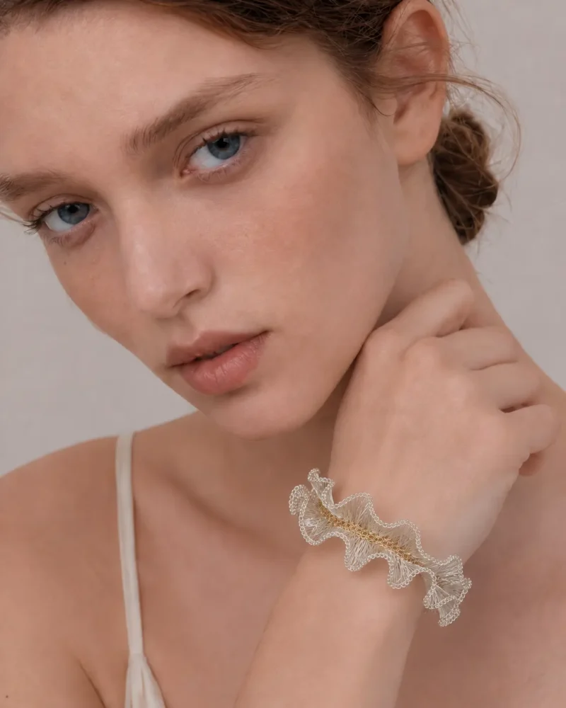 Close-up of model wearing OREYNE handmade ruffled silver wire bracelet