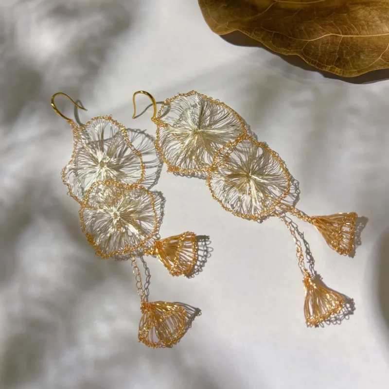 OREYNE handwoven gold-tone Morning Glory petal tassel earrings on white background