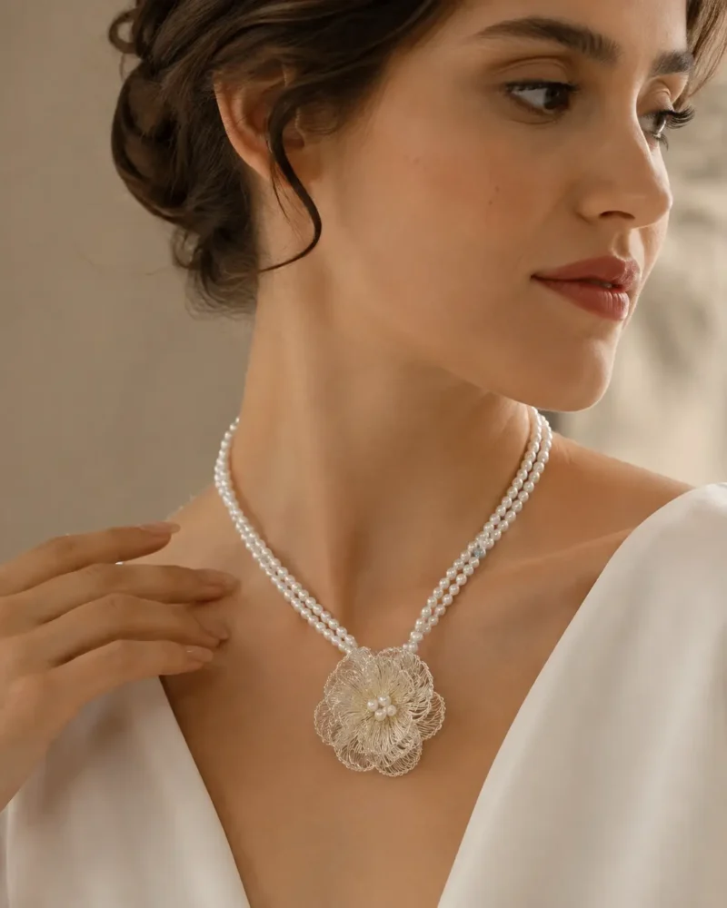Model wearing OREYNE handcrafted pearl necklace with silver wire flower pendant