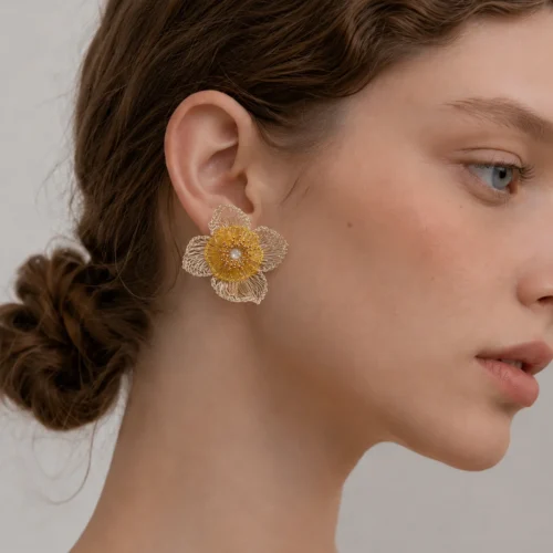 Woman wearing OREYNE Golden Coreopsis handwoven flower earrings