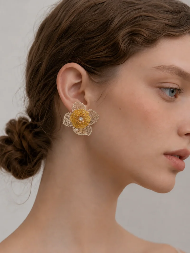 Woman wearing OREYNE Golden Coreopsis handwoven flower earrings