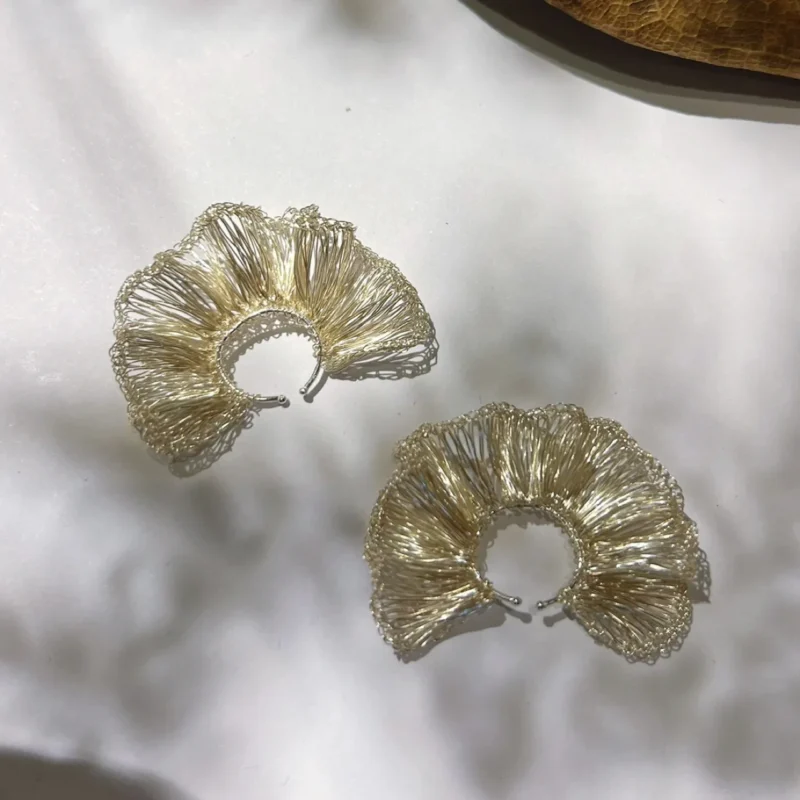 Close product view of handwoven Fine Silver-Plated Copper Wire hoop earrings with sculptural fan-like folds