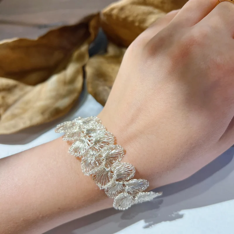 Handwoven Fine Silver-Plated Copper Wire floral bracelet worn on the wrist with layered openwork flower details