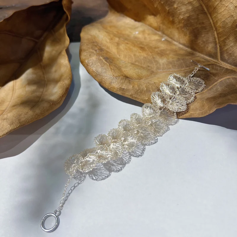 Handwoven Fine Silver-Plated Copper Wire floral link bracelet displayed flat with openwork flower details and toggle clasp