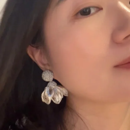 Front worn view of a silver-tone wire flower drop earring with a textured circular stud and open woven petals