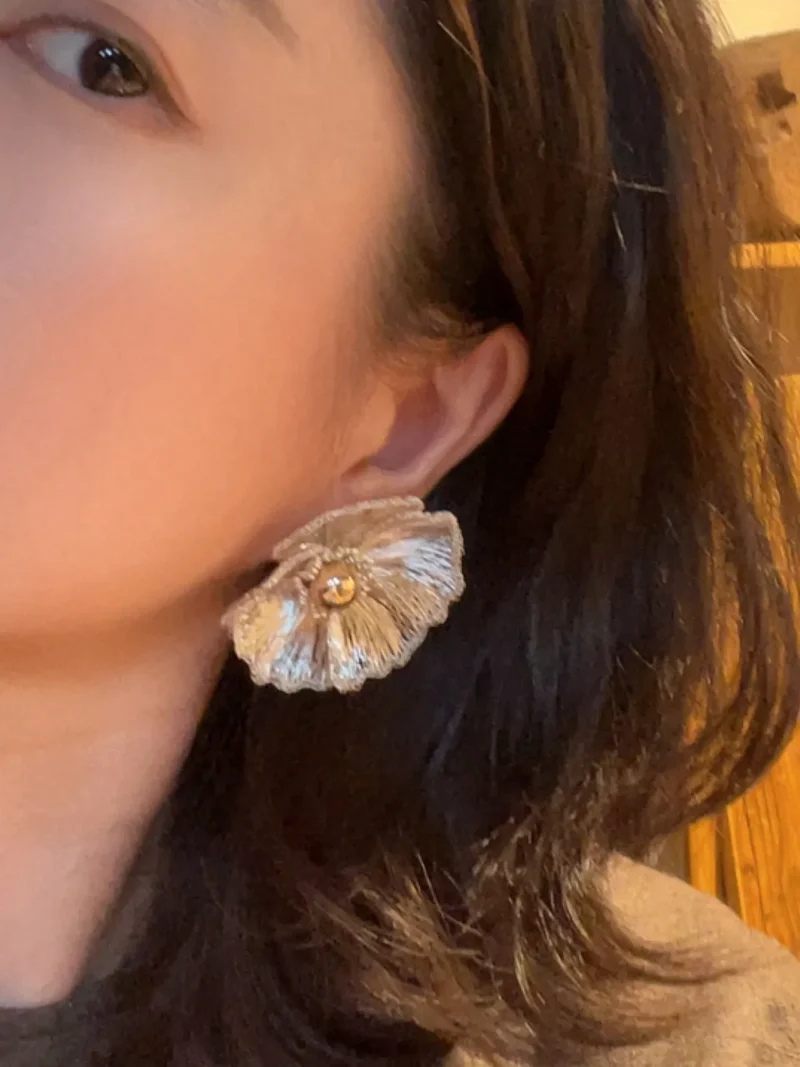 Model wearing OREYNE White Poppy sculptural stud earrings