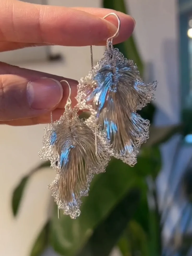 Handheld view of OREYNE Ruffled Leaf drop earrings