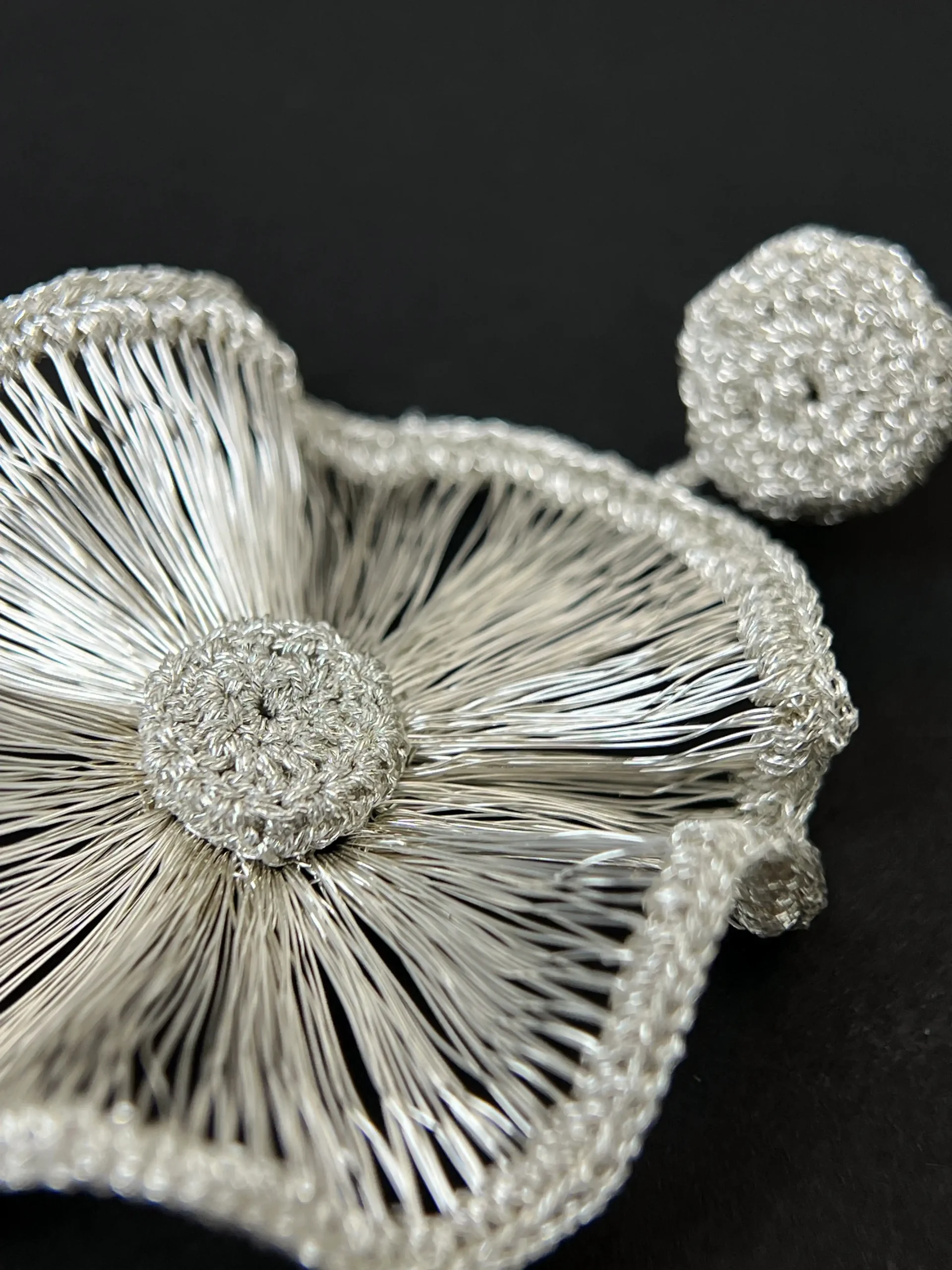 Close-up detail of OREYNE Radiant Bloom sculptural statement earrings