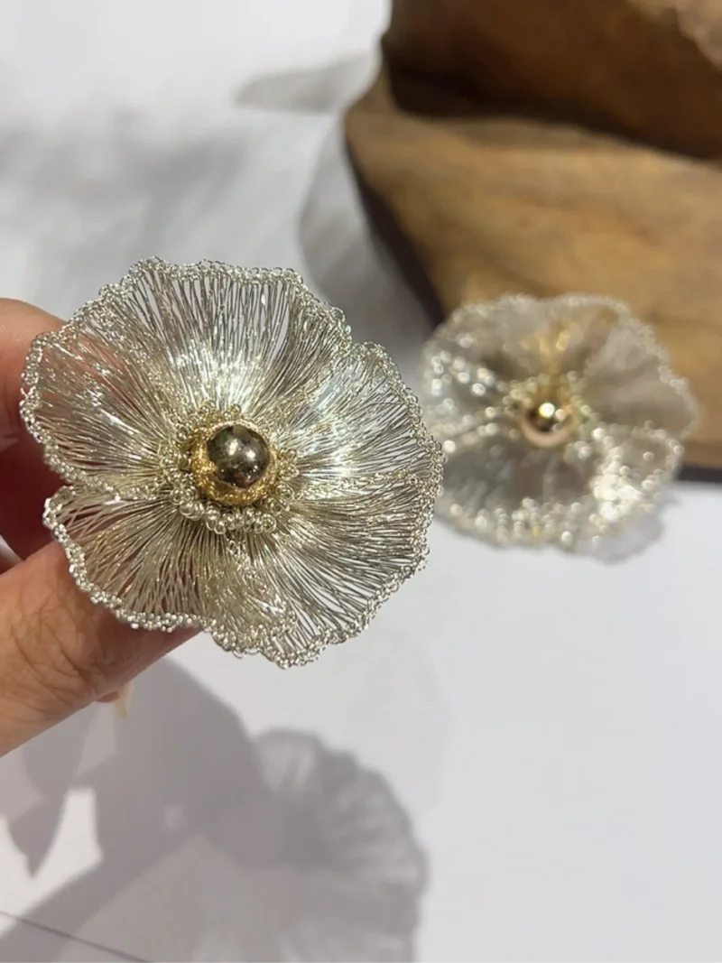 Handheld view of OREYNE White Poppy sculptural earrings