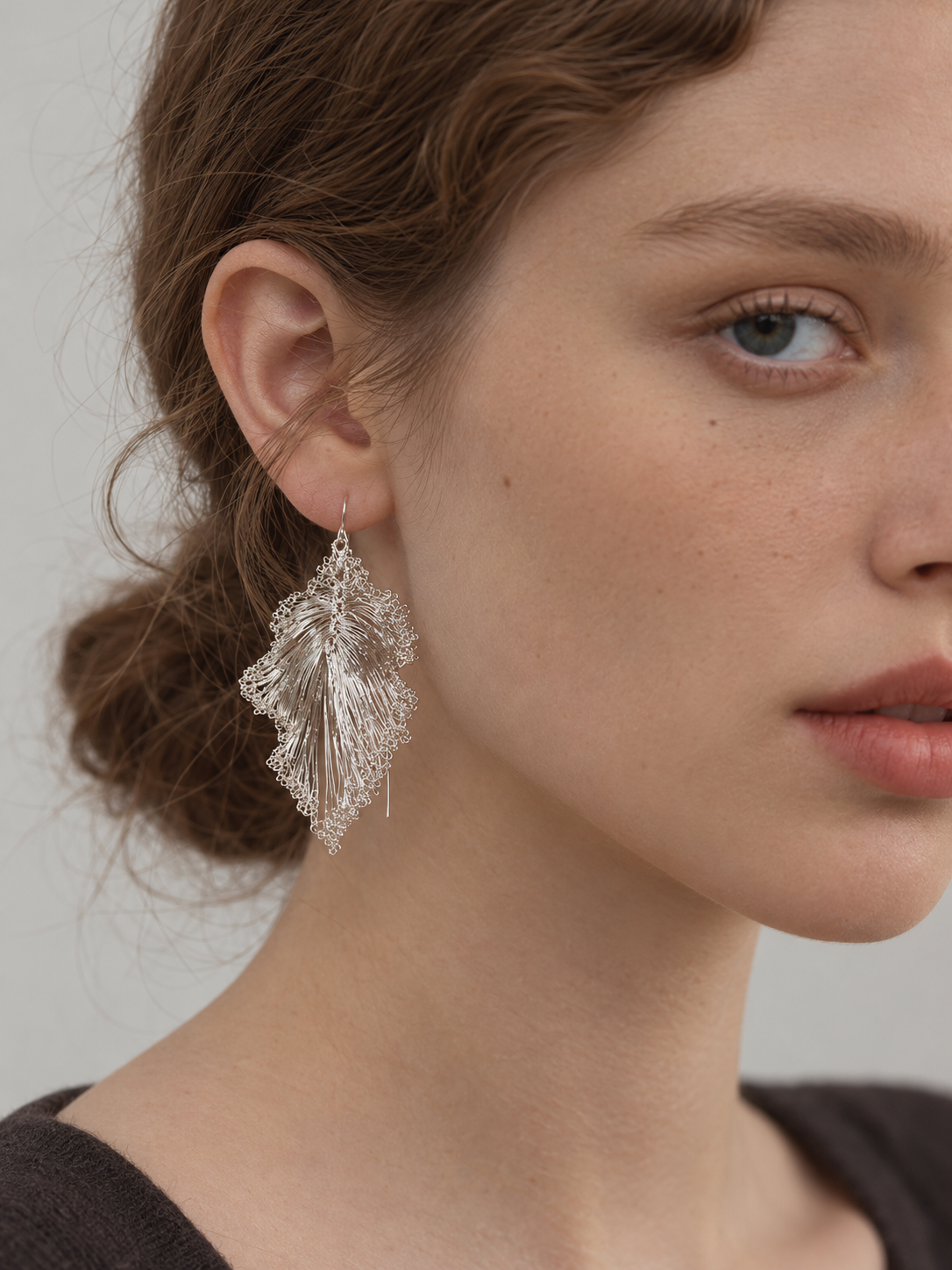 Model wearing OREYNE Ruffled Leaf sculptural drop earrings