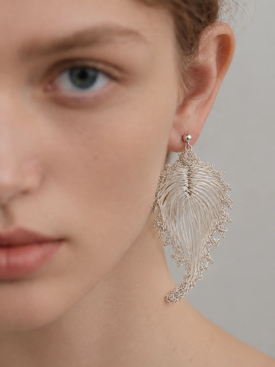 Model wearing silver-tone handwoven bodhi leaf drop earrings