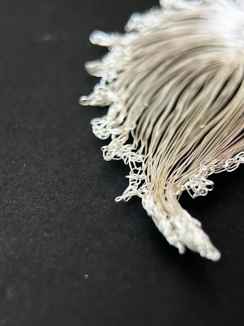 Handwoven bodhi leaf earrings shown on a dark background